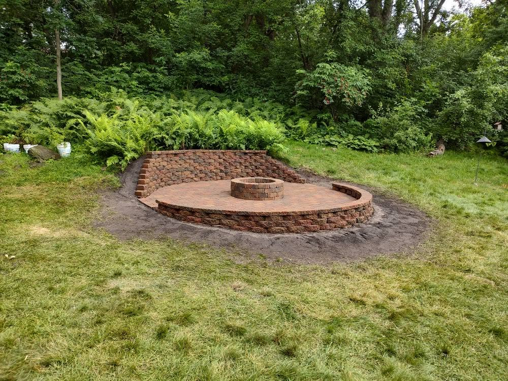 Circular stone fire pit with tiered retaining wall